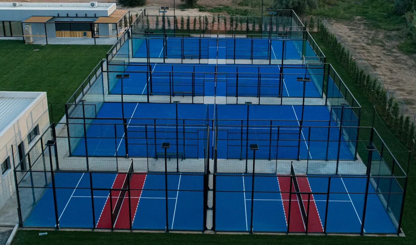 A four-court padel block at dusk